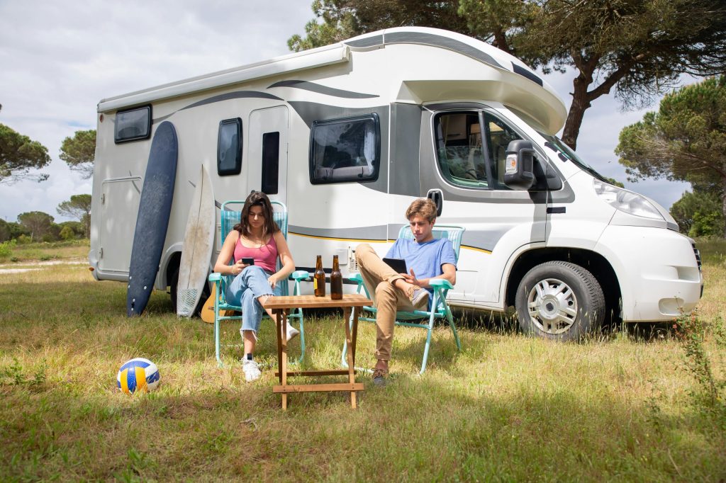 Off-grid adventure with a camper and two persons relaxing in front