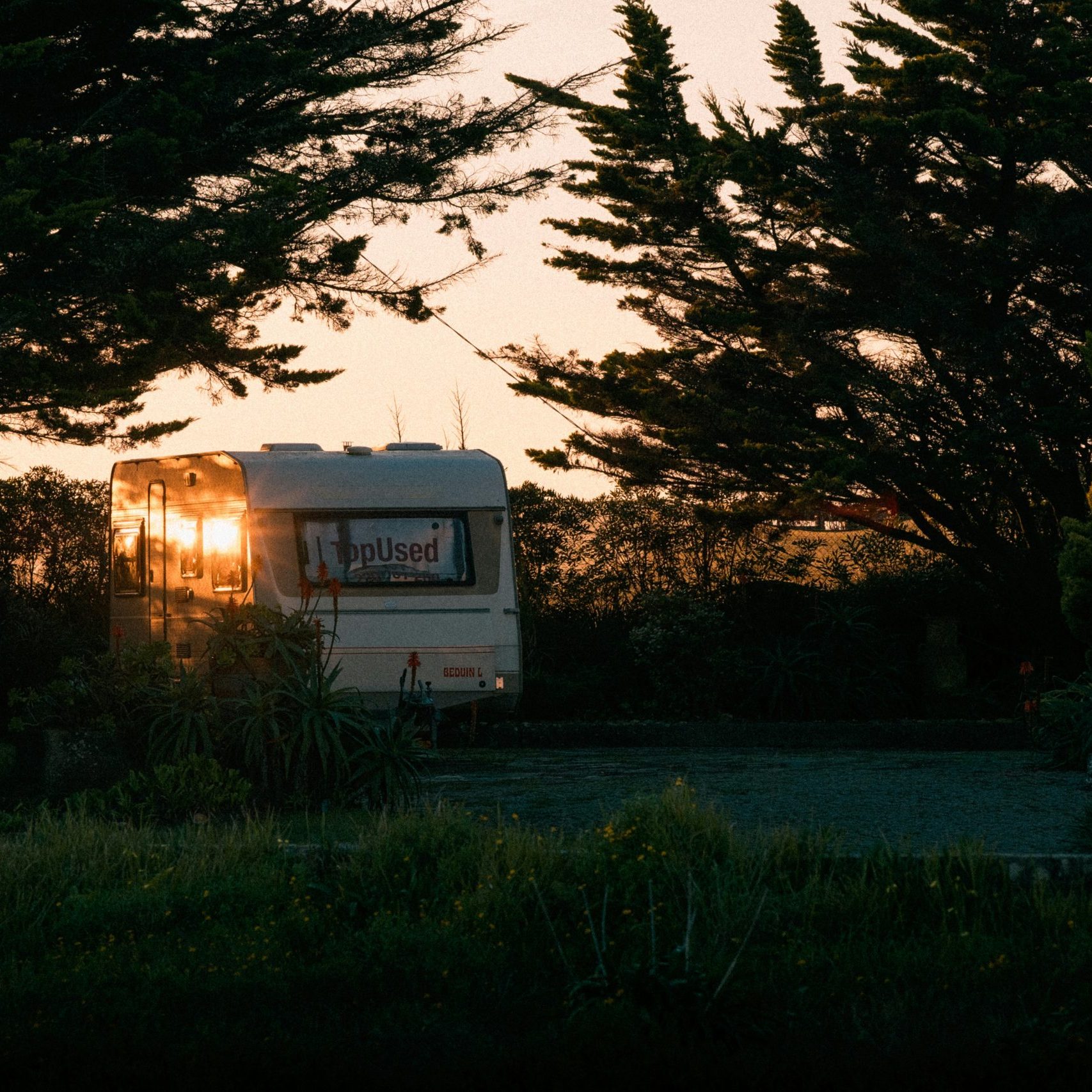 A caravan without solar panels for caravan roof in the sunset.